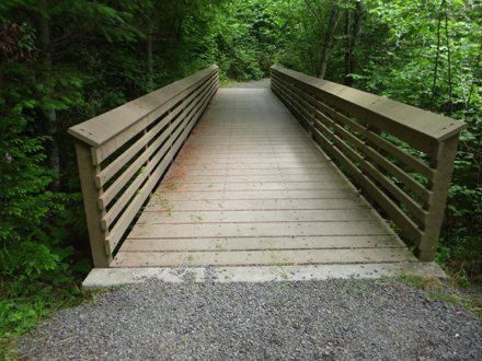 Foot bridge with a transition from compacted gravel to hard surface of composite boards Foot bridge with a transition from compacted gravel to hard surface of composite boards